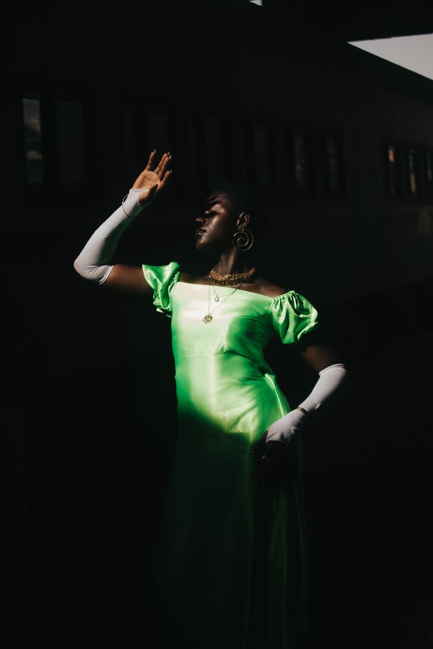 Artistic portrait of a woman in a green dress with dramatic shadows